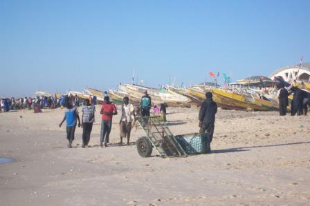 034_Eine_Pirogue_auf_dem_Land_mit_Maennern_und_Kisten